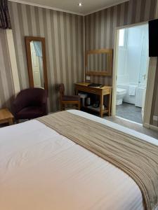 a hotel room with a bed and a bathroom at The Dog & Partridge Country Inn in Ashbourne +26 photos