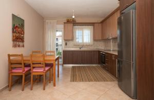 a kitchen with a table and chairs and a refrigerator at Villa Ilias in Flogita