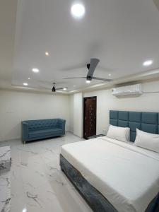 a bedroom with a large bed and a blue couch at G square The Premium Hotel in Rushikonda
