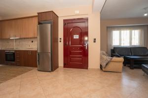 a kitchen with a refrigerator and a living room at Villa Ilias in Flogita