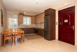 a kitchen with a wooden table and a refrigerator at Villa Ilias in Flogita