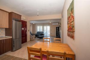 a kitchen and living room with a wooden table and chairs at Villa Ilias in Flogita