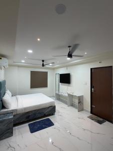 a bedroom with a bed and a flat screen tv at G square The Premium Hotel in Rushikonda