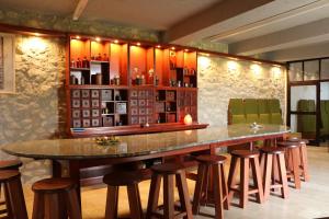a bar with a large table and some stools at István Király Szálló in Pécsvárad