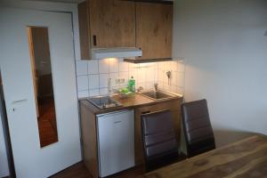 a small kitchen with a sink and two chairs at Ferienwohnung Ortlieb Laboe in Laboe