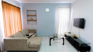 a living room with a couch and a table and a tv at Deluxe on Main in Roodepoort