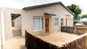 a house with a wooden fence in front of it at Deluxe on Main in Roodepoort