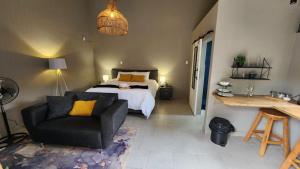 a bedroom with a bed and a couch and a chair at 14 on Maroela in Polokwane