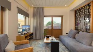 a living room with a couch and a tv at Querini Luxury Suites in Chania Town