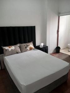 a bedroom with a large white bed with flowers on it at THEMBAGUESTHOUSe in Benoni +8 photos