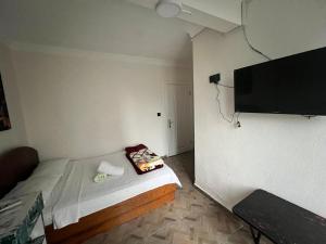 a small bedroom with a bed and a flat screen tv at Airport See Viem See Apartment in Arnavutköy
