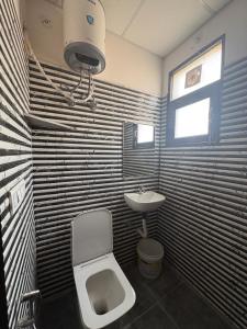 a bathroom with a toilet and a sink at Vansh Residency Couple Friendly Near Rajiv Chowk Gurgaon in Gurgaon +22 photos