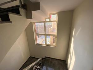 an empty room with a window and a staircase at Vansh Residency Couple Friendly Near Rajiv Chowk Gurgaon in Gurgaon