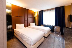a hotel room with two beds and a window at Hotel Ciao in Târgu-Mureş