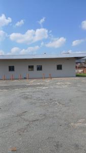 a large white building with windows in a parking lot at THEMBAGUESTHOUSe in Benoni