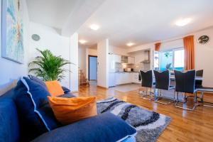salon z niebieską kanapą i kuchnią w obiekcie Rainbow apartments w mieście Zadar
