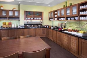 a large kitchen with wooden cabinets and a table at Hyatt Place Phoenix/ Mesa in Mesa