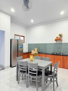 a kitchen with a table and chairs and a refrigerator at HOMESTAY- Hưng Thịnh in Vạn Ninh +6 photos