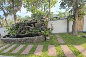 a garden with a stone fountain in a yard at Sufficient House in Nong Prue