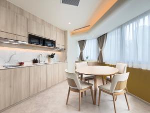 a kitchen and dining room with a table and chairs at Coliwoo Midtown - CoLiving in Singapore