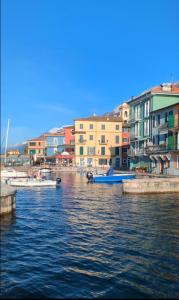 un groupe de bateaux dans une étendue d'eau avec des bâtiments dans l'établissement Casa Valle - Lago di Garda, à Brenzone
