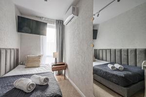 a bedroom with two twin beds and a television at Prestige Center Warsaw Rooms Metro, AC, Smart TV, 2 Bathrooms in Warsaw