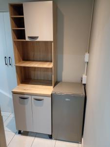 a kitchen with a refrigerator and a shelf at Ashdown BnB in Pietermaritzburg