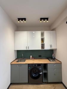 a kitchen with white cabinets and a washing machine at Bakuriani in Bakuriani