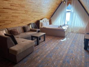 a living room with a bed and a couch at Şəki Yaylası Hotel in Sheki