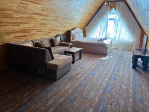 a living room with a couch and a bed at Şəki Yaylası Hotel in Sheki