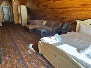 a living room with a bed and a couch at Şəki Yaylası Hotel in Sheki