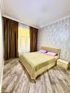 a bedroom with a large bed with pink pillows at Qax home in Qax