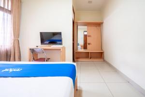 a hospital room with a bed and a television at Rehat at Hotel Kurnia Karapitan in Bandung