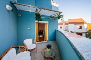 balkon z łóżkiem i krzesłem na niebieskiej ścianie w obiekcie Rainbow apartments w mieście Zadar