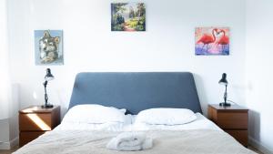 a white dog laying on a bed in a bedroom at Wellocum in Serock
