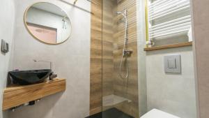 a bathroom with a shower with a sink and a mirror at Wellocum in Serock