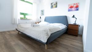 a bedroom with a blue bed and a window at Wellocum in Serock