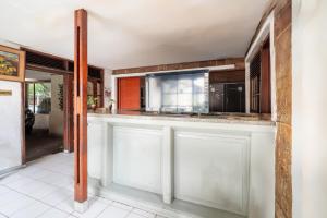 a kitchen with white cabinets and a counter top at Rehat at Hotel Kurnia Karapitan in Bandung