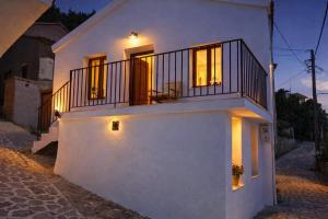 a white house with a balcony on a street at Armonia Cosy Loft Chora Samothraki View in Samothraki