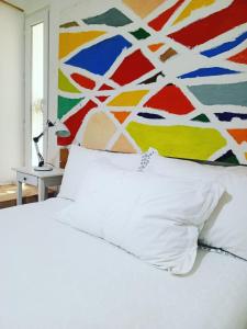 a bedroom with a white bed and a colorful wall at Greek Style Bed & Breakfast in Al Manashsh