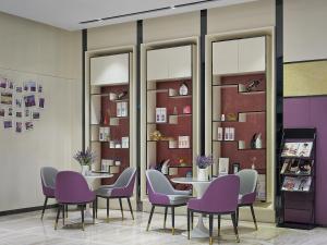 a dining room with purple chairs and tables and mirrors at Lavande International Hotel Guangzhou Baiyun International Airport Renhe Metro Station Branch - Free Shuttle Bus to Guangzhou Baiyun International Airport in Guangzhou +69 photos