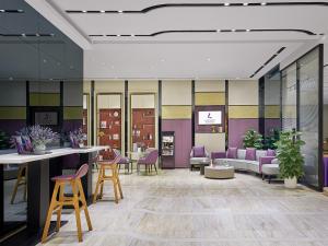 a lobby with chairs and tables in a building at Lavande International Hotel Guangzhou Baiyun International Airport Renhe Metro Station Branch - Free Shuttle Bus to Guangzhou Baiyun International Airport in Guangzhou