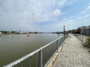 a body of water with a fence next to a river at Kỳ Duyên House in Cái Răng