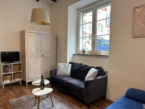 a living room with a black couch and a table at Rheingold inklusive einer Flasche Sekt in Koblenz