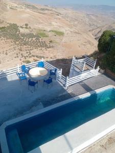 an overhead view of a pool with chairs and a table at Greek Style Bed & Breakfast in Al Manashsh
