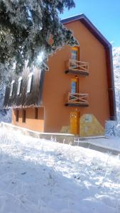 a building with snow on the ground in front of it at Apartments Aurelius in Jahorina