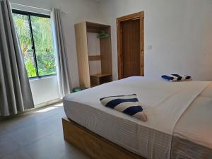 a bedroom with a bed with two pillows on it at Garden Rooms by Shams Thoddoo in Thoddoo