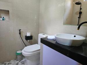 a bathroom with a white sink and a toilet at Garden Rooms by Shams Thoddoo in Thoddoo +20 photos