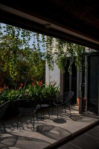 a patio with chairs and plants in a yard at Ozonizia Family Suites Mai Khao Phuket Yacht Haven in Phuket