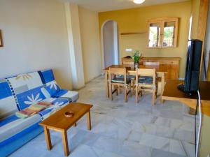 a living room with a blue couch and a table at Bertur San Antonio Mar in Alcossebre